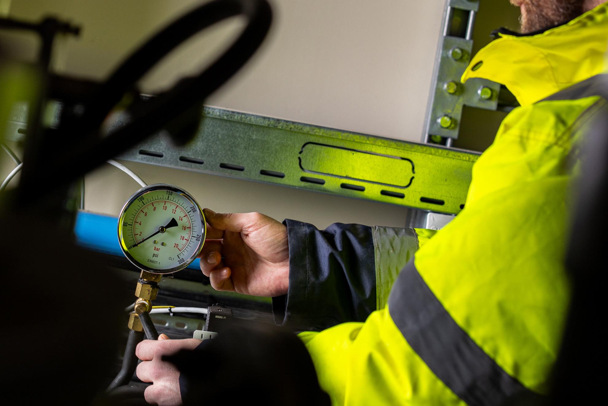 Operative inspecting a gauge