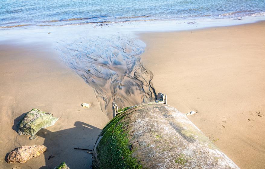 sewage pipe leading to a beach
